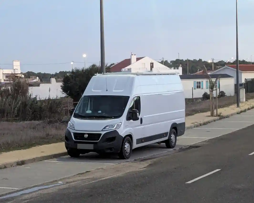 A van build parked on a street — an unmarked white panel van